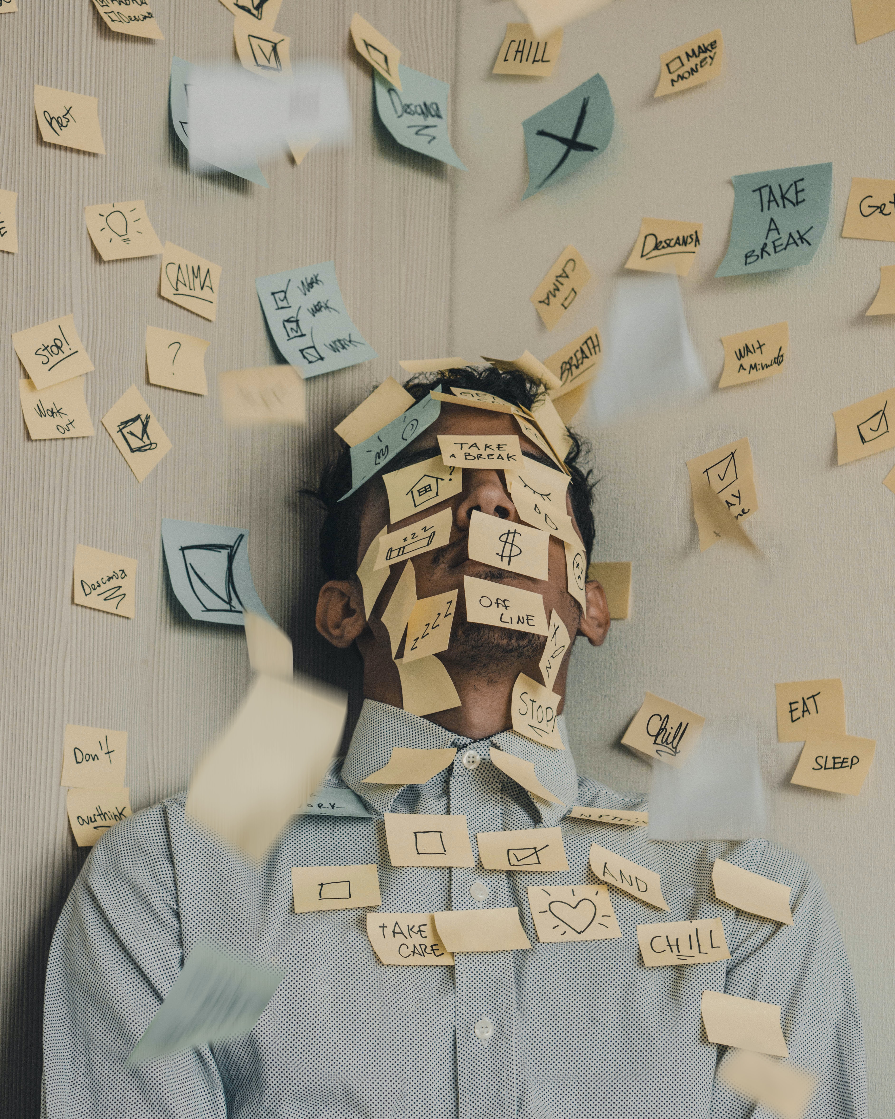 bored man covered in sticky notes not doing work