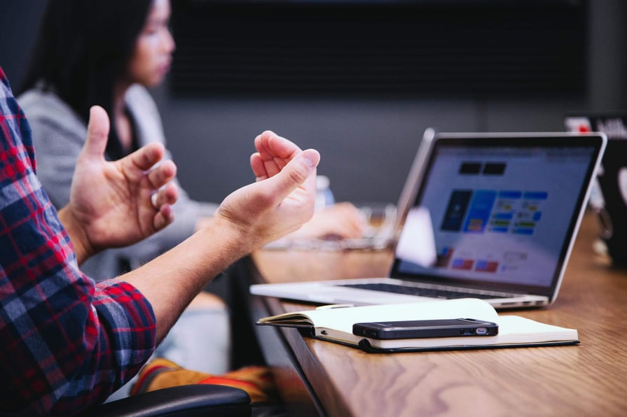 Cirrus Insight. Employee talks during a meeting with hand motions.