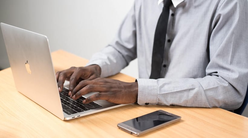 Cirrus Insight. Man types on laptop with phone next to him.