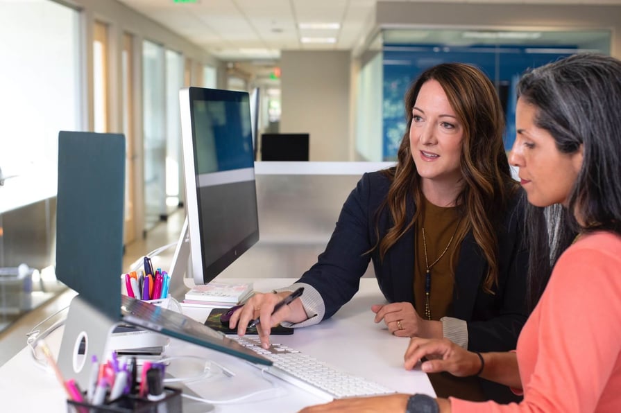 Cirrus Insight. Manager assisting a subordinate on the computer.